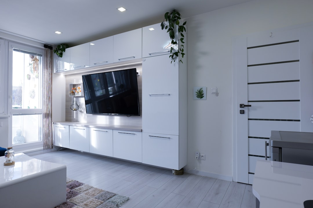 Modern living room with white entertainment unit and tv.